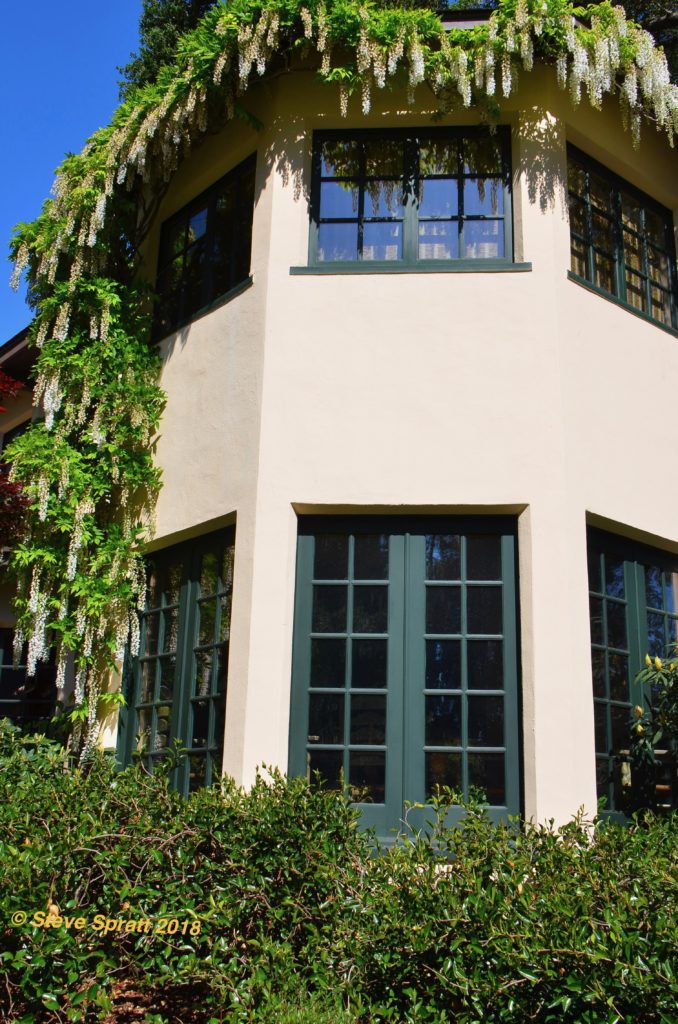 Image of two story home hexagon stucco sided turret with large windows